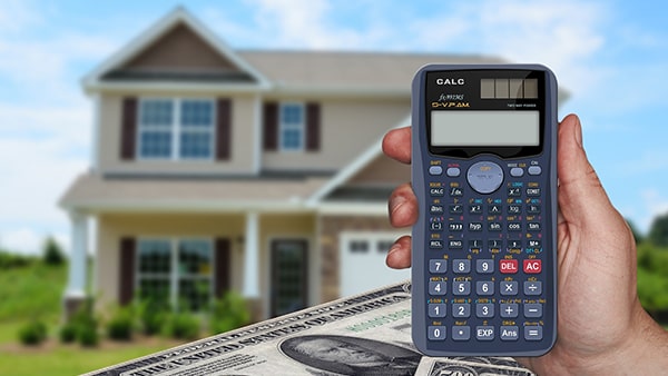 Calculator with house and money in background